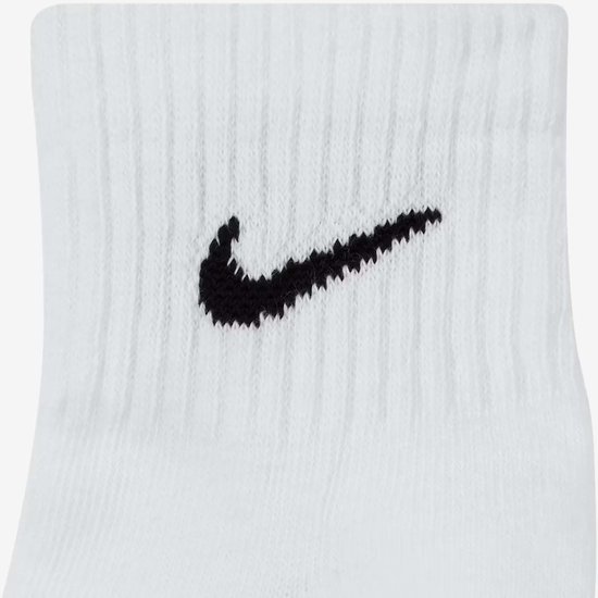 Close-up van een witte Nike enkelsok met zwart Nike logo.
