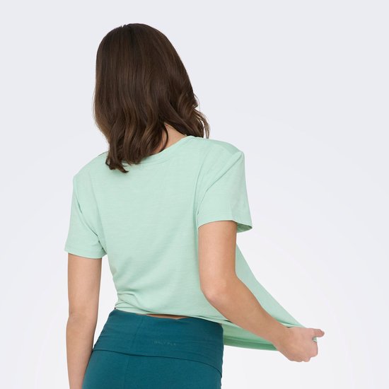 Model van achteren in lichtgroen t-shirt met V-hals.