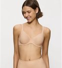 Model lacht en draagt een huidkleurige beugelbeha met verticale strepen.