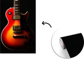 Behang - Fotobehang Een roodkleurige elektrische gitaar - Breedte 150 cm x hoogte 220 cm