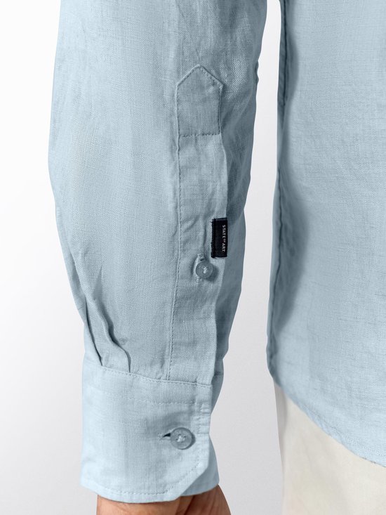 Mouwdetail van een lichtblauwe linnen herenhemd met 'State of Art' label.