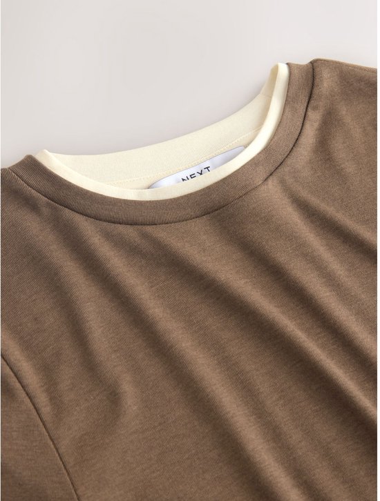 Nekdetail van een bruin T-shirt met crème binnenkraag, met het merklogo.