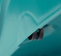Détail des roulettes noires sous un seau turquoise.