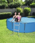 Vrouw en meisje in badkleding bij een ronde blauwe zwembad met een grijze ladder.
