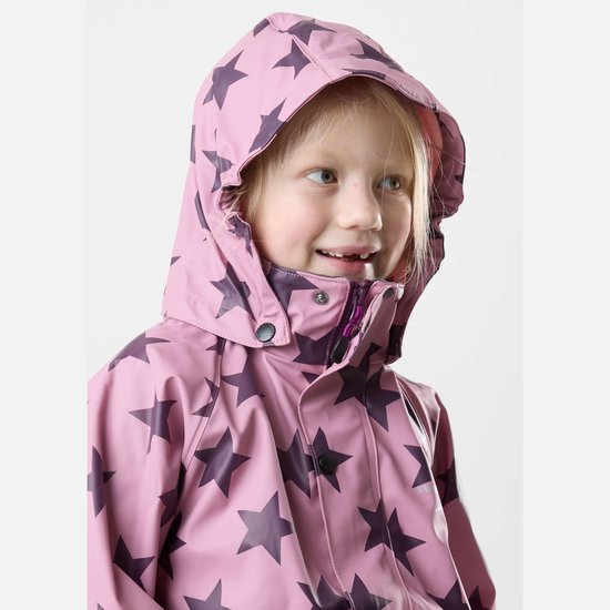 Close-up van een lachend meisje met blonde paardenstaart, draagt een roze regenjas met donkerpaarse sterrenprint en bijpassende hoed.