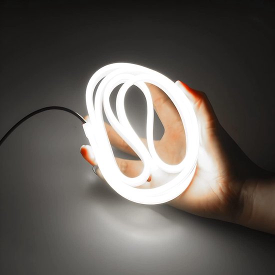 Een hand houdt een helder witte, opgerolde LED strip vast.