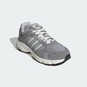 Grijze Adidas sneaker met witte veters, lichtgrijze strepen en witte zolen.