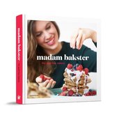 Boek "Madam Bakster the guilt-free bakery" met een gestapelde toren van pannenkoeken versierd met bessen, terwijl een vrouw ze belegd met frambozen.