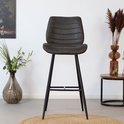Antracietkleurige barkruk met horizontale stiksels, zittend op een jute mat in een interieur.
