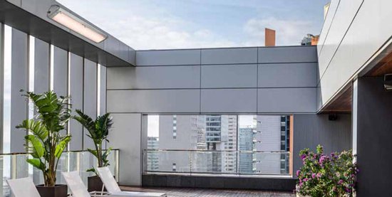 Terrasverwarmer aan het plafond van een modern dakterras met uitzicht op de stad.