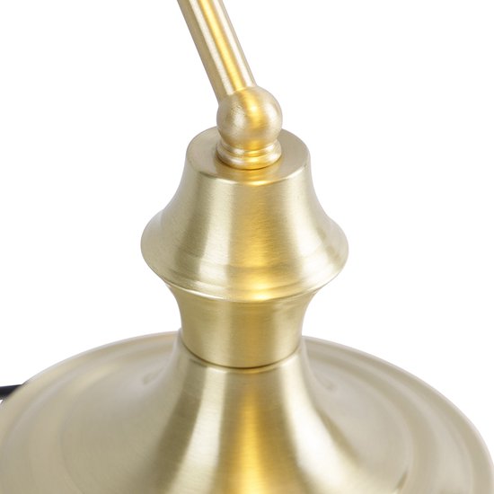 Gros plan du pied doré et de la tige courbée d'une lampe de bureau.