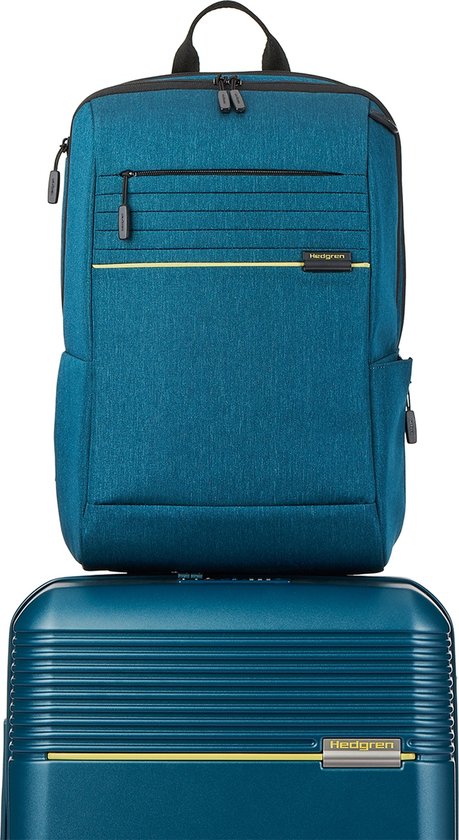 Blauwe Hedgren laptoprugzak met gele accenten, bovenop een blauwe koffer.