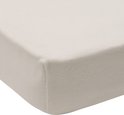 Hoek van een crèmekleurig jersey hoeslaken voor een boxmatras.
