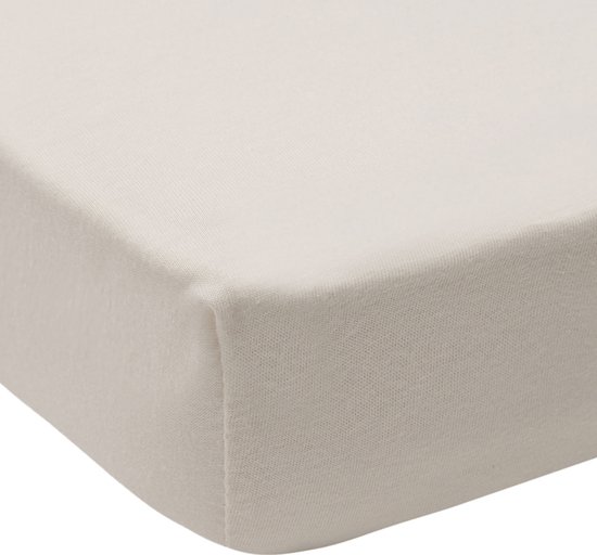 Hoek van een crèmekleurig jersey hoeslaken voor een boxmatras.