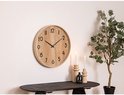 Houten wandklok met zwarte cijfers en wijzers, aan een witte muur.