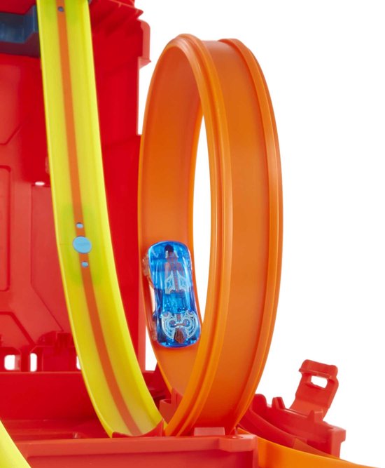 Une voiture Hot Wheels bleue fait un looping sur une piste orange, partie du set Hot Wheels Track Builder rouge.