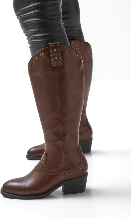Bruine laarzen met studs en lage hak gedragen met zwarte broek.
