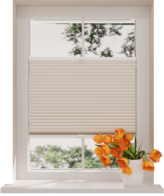 Store plissé couleur sable dans un cadre blanc, avec un vase de tulipes orange sur le rebord de fenêtre.