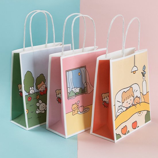 Trois sacs fourre-tout en papier avec des illustrations de dessins animés : dans un parc, près de la fenêtre et dormant au lit.