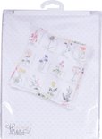 Emballage avec un coussin présentant des broderies en point de croix de fleurs sauvages.