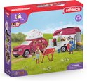 Schleich paardenspeelset met rode auto, paardentrailer en figuren in een zonnig landschap.