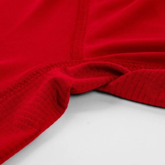 Détail de l'entrejambe d'un t-shirt rouge texturé.