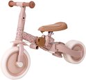 Roze loopfiets met bloemenprint en bruin zadel.