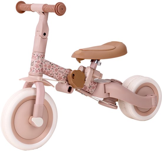 Roze loopfiets met bloemenprint en bruin zadel.
