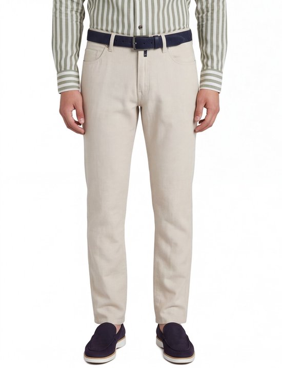 Model draagt een beige broek met vijf zakken, gecombineerd met een groen-witte gestreepte blouse en marineblauwe riem.