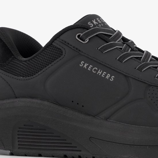 Close-up van de zijkant van een zwarte Skechers instapper met veters.