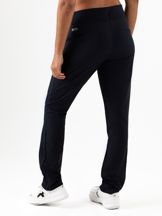 Achterkant van een model in een donkerblauwe stretch trainingsbroek met witte sneakers.
