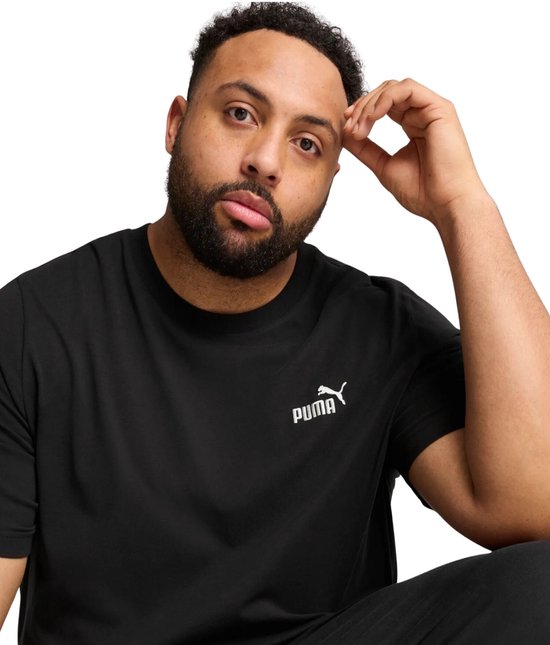 Man draagt een zwarte PUMA t-shirt met een klein wit PUMA-logo op de borst.