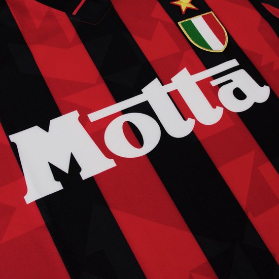 Close-up van het rood-zwarte voetbalshirt met de witte 'Motta'-bedrukking en het scudetto-schild.