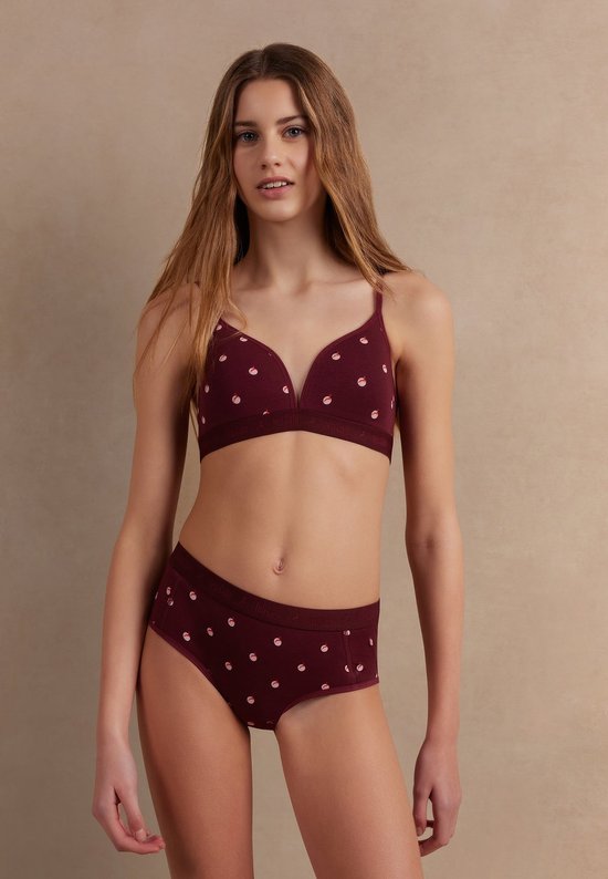 Model draagt een bordeauxrode Ten Cate bh en slip met een subtiel hertenpatroon.