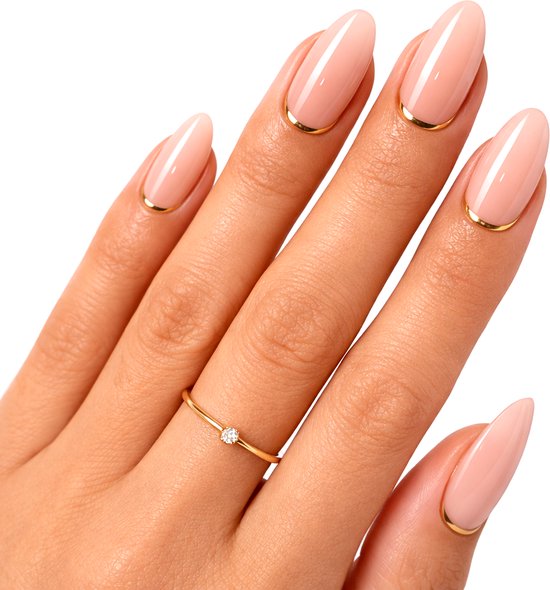 Hand met ovale nepnagels in nude met een dun gouden accent aan de basis.