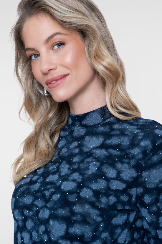 Blauwe top met een all-over dierenprint en subtiele glitterdetails, gedragen door een model.