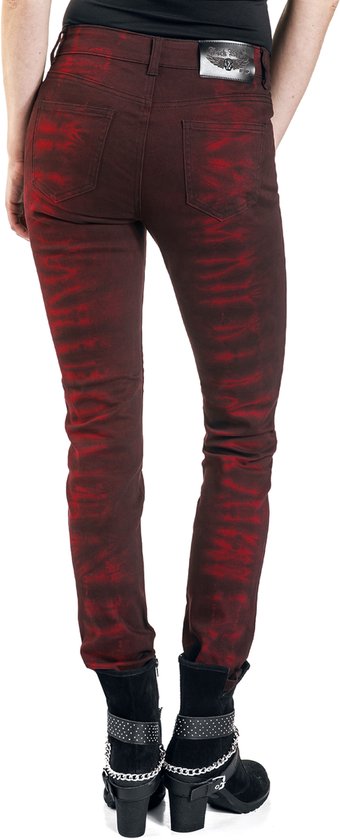 Achterkant van een rode broek met zwarte batikprint, gedragen met zwarte laarsjes.