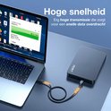 Een zwarte datakabel verbindt een laptop met een externe harde schijf. Tekst: Hoge snelheid.