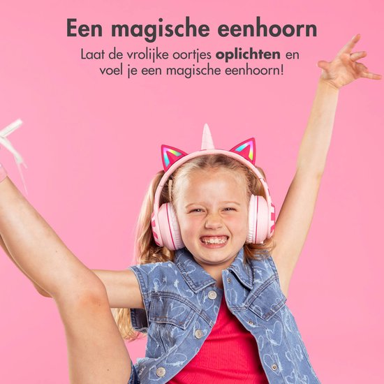 Een lachend meisje met een roze unicorn koptelefoon met oplichtende oren.