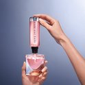 Handen vullen Lancôme La Vie est Belle parfumfles bij met een navulfles. Roze parfum.