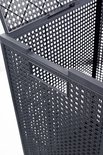 Gedetailleerd beeld van de zijkant van een antracietkleurige wasmand met handvat en opengewerkt patroon.