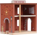 Houten brandweerkazerne met gedetailleerde muurschilderingen, ramen en een ladder aan de binnenkant.