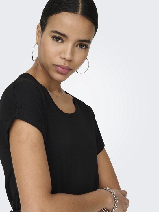 Close-up van een vrouw in een zwart T-shirt met opgerolde mouwen.