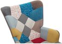 Close-up van een patchwork fauteuil met diverse patronen zoals ruiten en lijnen in verschillende kleuren.