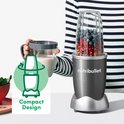 Nutribullet blender met blauwe bessen en frambozen in de beker. Compact design.