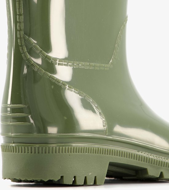 Detail van de zool en zijkant van een olijfgroene regenlaars met opgestikte naden.