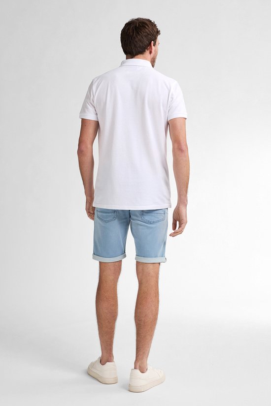 Man met witte polo en lichte denim shorts, staand, de achterkant.