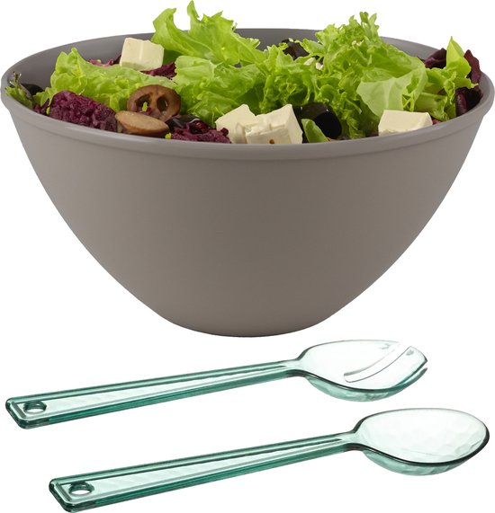 Grijze serveerschaal gevuld met salade, met een groen saladebestek ernaast.