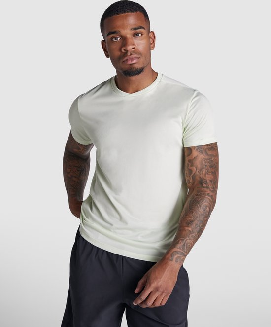 Close-up van een lichtgroen Roly sportshirt met korte mouwen, gedragen door een man met tatoeages.