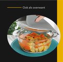 Grijze pannenonderzetter in gebruik als ovenwant om een hete glazen schaal vast te pakken.